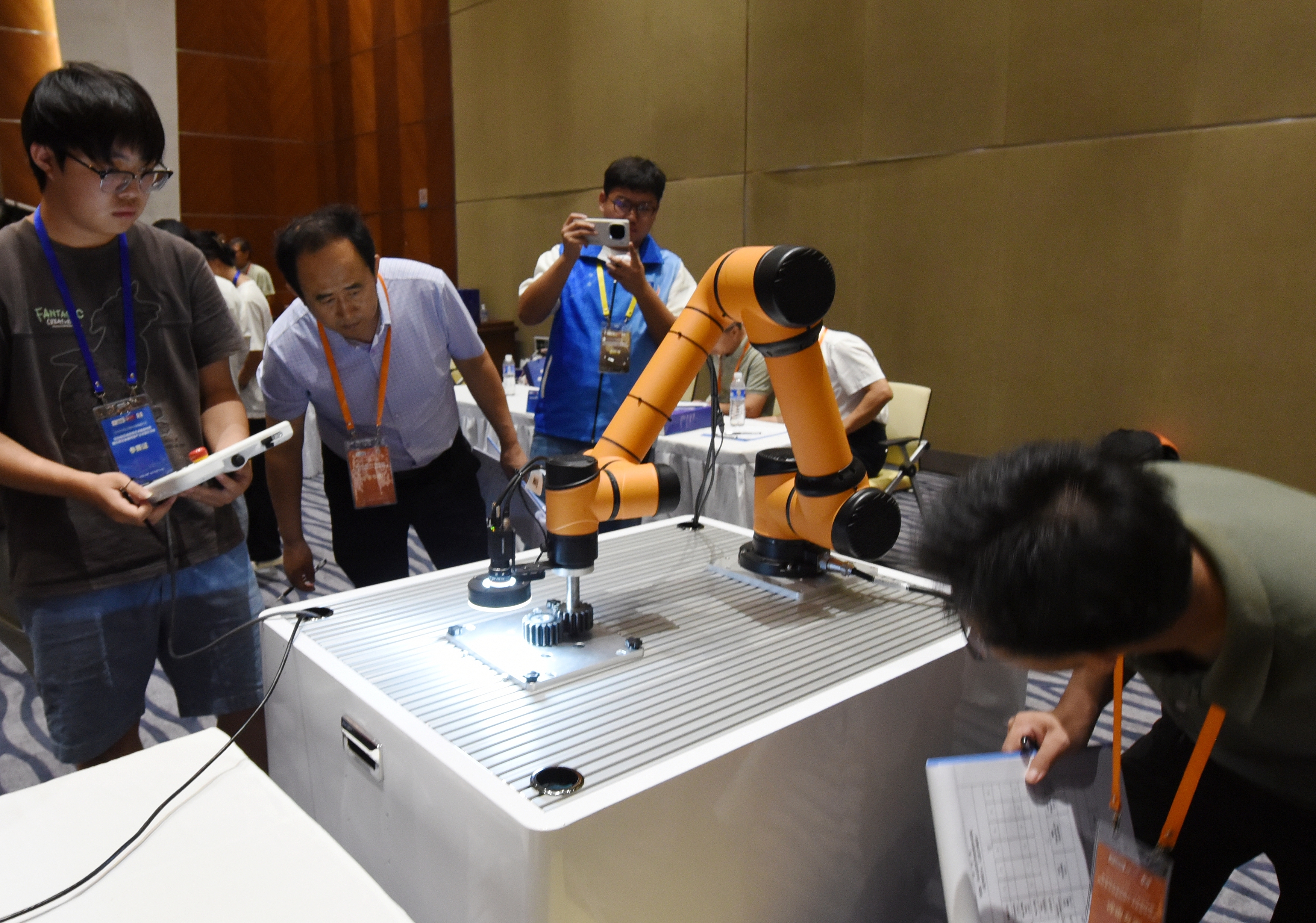 2025年中國大學(xué)生機(jī)械工程創(chuàng)新創(chuàng)意大賽智能精密裝配賽京津冀魯聯(lián)賽現(xiàn)場，評委對參賽選手進(jìn)行實(shí)操調(diào)試評比。